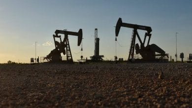 Un baril de pétrole devant une installation pétrolière, alors que les cours du brut reculent sur les marchés mondiaux